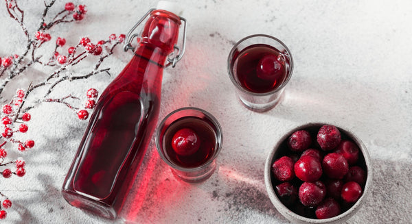 Red liqueur bottle and glasses with Christmas Berry Liqueur.