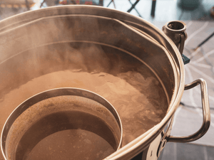 Steaming brewing vat during the beer making process, where the EasyDens by Anton Paar can be used to measure the density and concentration of the brew.